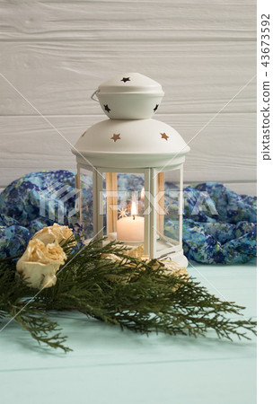 White lantern and dried roses with juniper branche 43673592