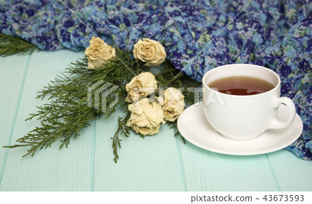 Cup of tea with dried roses and branches of junipe Cup of tea with dried roses and branches of junipe 43673593