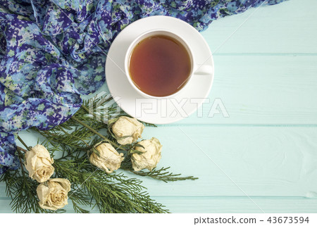 Cup of tea with dried roses and branches of junipe 43673594