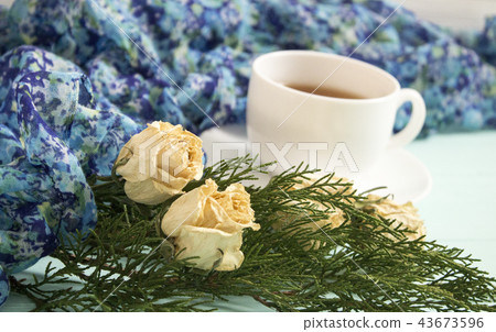 Cup of tea with dried roses and branches of junipe 43673596