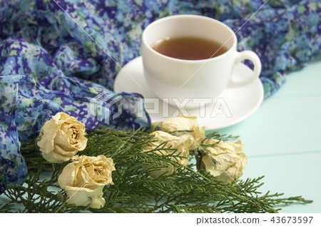 Cup of tea with dried roses and branches of junipe Cup of tea with dried roses and branches of junipe 43673597
