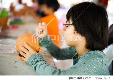 Asian little girl drawing and painting on pottery Asian little girl drawing and painting on pottery 43679797