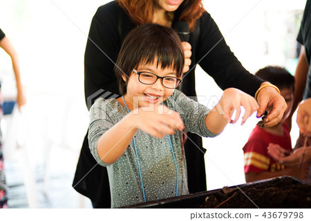 Asian girl holding the earthworms by her hands Asian girl holding the earthworms by her hands 43679798