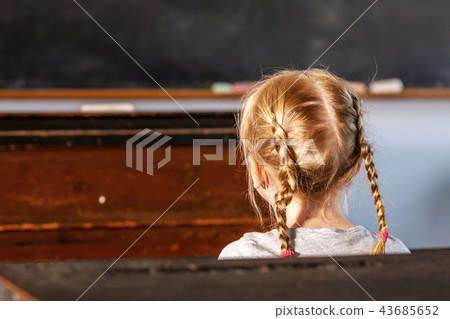 Concept of public primary school education with young girl in the classroom 43685652