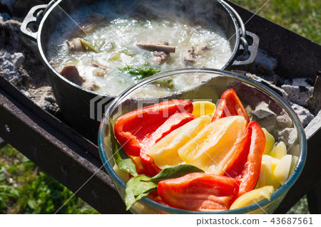 Shurpa soup in a large cast-iron cauldron outdoor. Shurpa soup in a large cast-iron cauldron outdoor. 43687561
