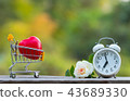 Red heart shape in shopping cart and white clock 43689330