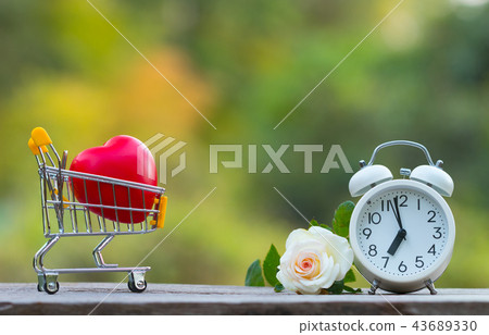 Red heart shape in shopping cart and white clock 43689330