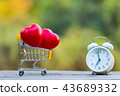 Red heart shape in shopping cart and white clock 43689332