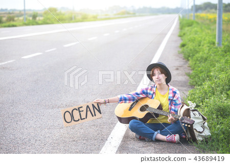 girl with a guitar hitch-hiking girl with a guitar hitch-hiking 43689419