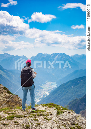 Hiker woman standing up achieving Dolomites Alps. 43690046