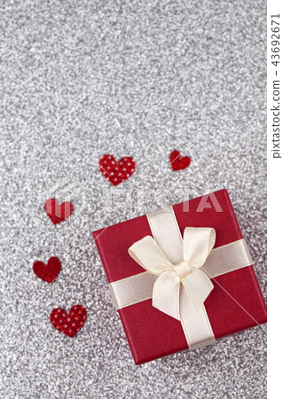 Gift box with hearts on silver background Gift box with hearts on silver background 43692671