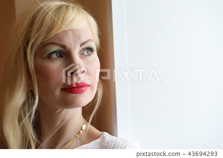 Cute girl is standing by the window looking Cute girl is standing by the window looking 43694293