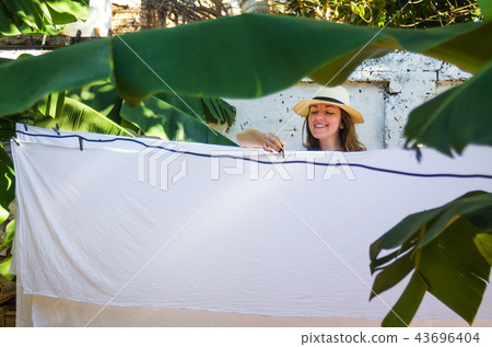 Girl hanging laundry on a clothes line Girl hanging laundry on a clothes line 43696404