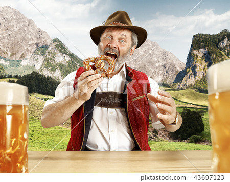 Germany, Bavaria, Upper Bavaria, man with beer dressed in traditional Austrian or Bavarian costume 43697123