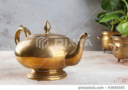 Vintage bronze tea pot and green plants 43698565