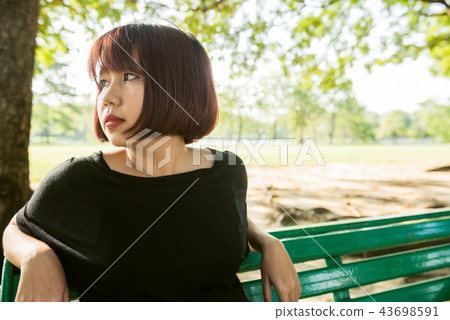 woman sit alone on the public bench in the park. 43698591