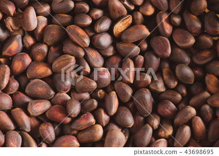 Pine nuts in shells of ciberian cedar as a background. Macro Pine nuts in shells of ciberian cedar as a background. Macro 43698695