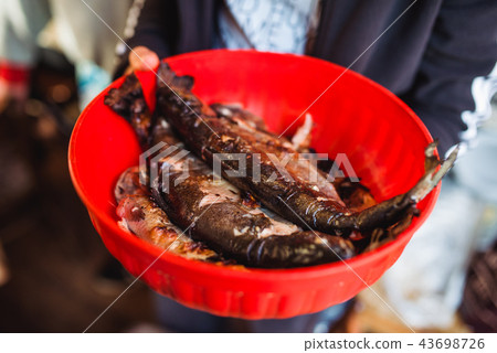 man holding Grilled fish in red Bowl man holding Grilled fish in red Bowl 43698726