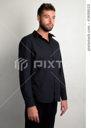 Studio shot of young handsome bearded businessman 43699020