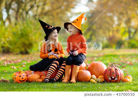 Kids with pumpkins in Halloween costumes Kids with pumpkins in Halloween costumes 43700550