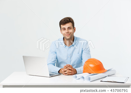 Handsome male construction engineer working in the office with laptop Handsome male construction engineer working in the office with laptop 43700791