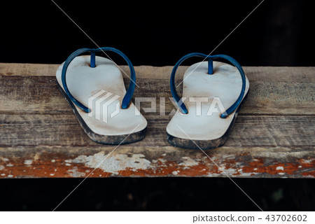 Sandal or flip-flop blue color on wooden staircase Sandal or flip-flop blue color on wooden staircase 43702602