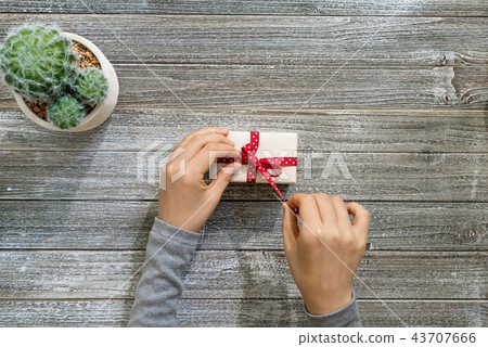 Woman with a present box on a wood desk 43707666