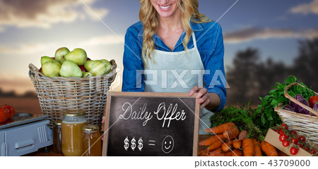 Composite image of happy woman with chalkboard and carrots Composite image of happy woman with chalkboard and carrots 43709000