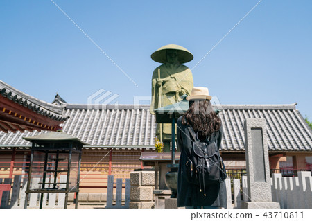female visitor standing in front of statue 43710811