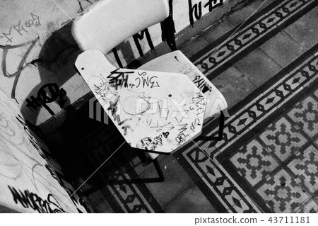 Worn school chair in black and white. 43711181