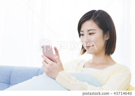 A young woman operating a smartphone A young woman operating a smartphone 43714640