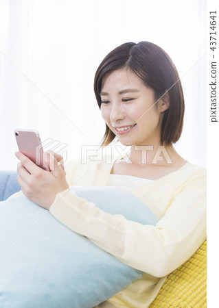 A young woman operating a smartphone A young woman operating a smartphone 43714641