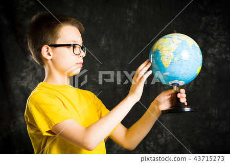 Schoolboy exploring world through a globe 43715273