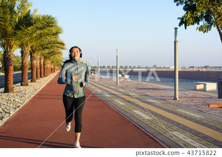 Girl jogging on the running track, active lifestyle Girl jogging on the running track, active lifestyle 43715822