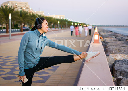 Girl preparing for a workout by the seaside Girl preparing for a workout by the seaside 43715824
