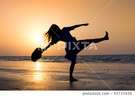 Girl on the beach at sunset Girl on the beach at sunset 43715839