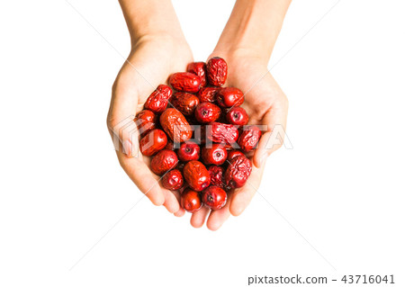 Hand holding Chinese red dates isolated 43716041