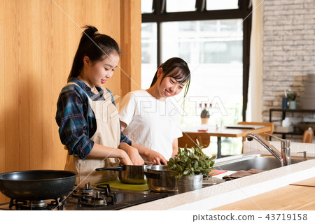 Two girls standing in the kitchen Two girls standing in the kitchen 43719158