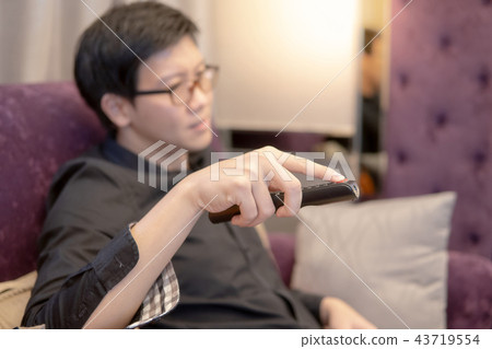 Asian man using remote controller while watching TV 43719554