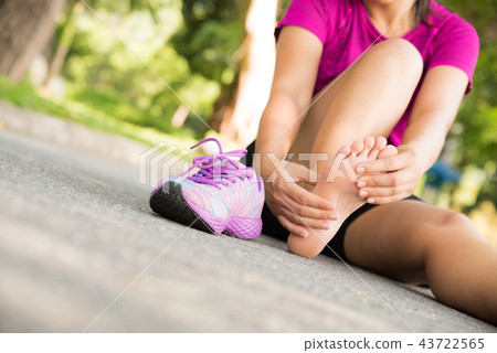 Young woman massaging her painful foot Young woman massaging her painful foot 43722565