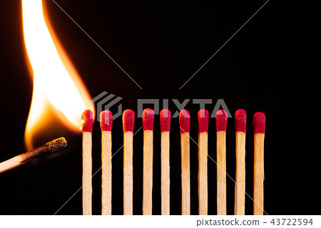 Lit match next to a row of unlit matches 43722594