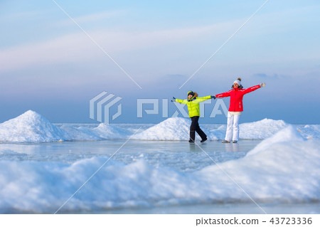 Young mother and her son on icy beach 43723336