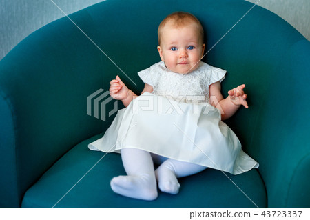 Portrait of happy little child wearing white dress in casual clothes posing indoors 43723337