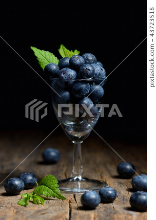 Blueberries with leaves on wooden table 43723518