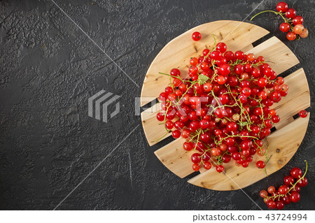 Red currant berries lying on gray background Red currant berries lying on gray background 43724994