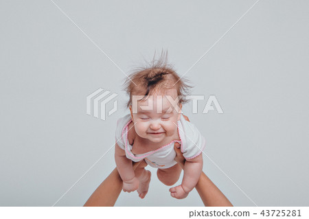 Dad raised his daughter in his arms on a white 43725281