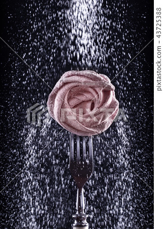 pink sweet marshmallow on fork on dark background. 43725388