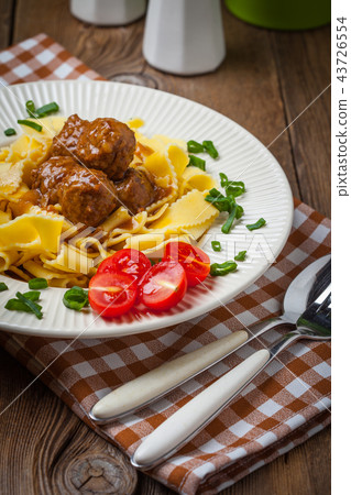 Tagliatelle, meatballs in dark sauce and tomato. 43726554