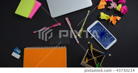 Composite image of laptop, mobile phone and stationery on black background Composite image of laptop, mobile phone and stationery on black background 43730214