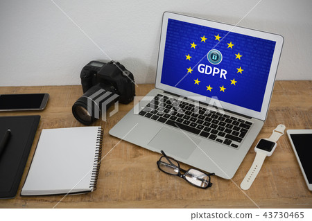 Composite image of laptop, wristwatch, notepad, camera and mobile phone on wooden table 43730465